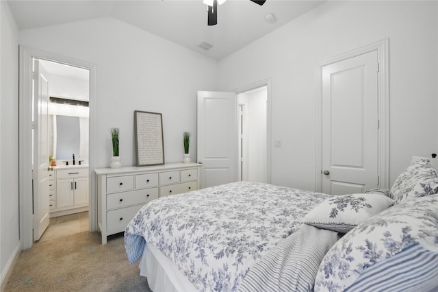 bedroom with light carpet, vaulted ceiling, ensuite bathroom, a sink, and ceiling fan
