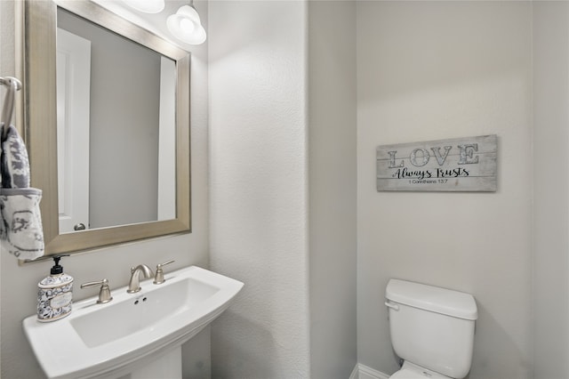half bath featuring a sink and toilet