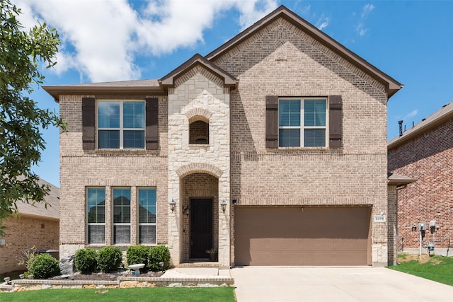view of front of house featuring brick siding, an attached garage, and driveway