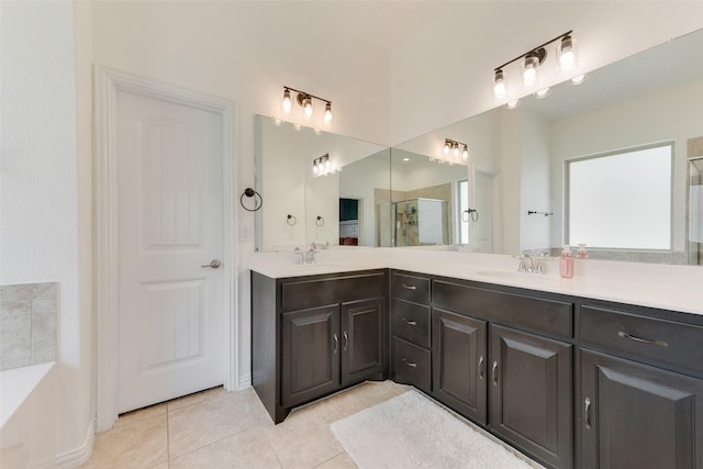 full bath featuring a shower stall, tile patterned flooring, double vanity, and baseboards