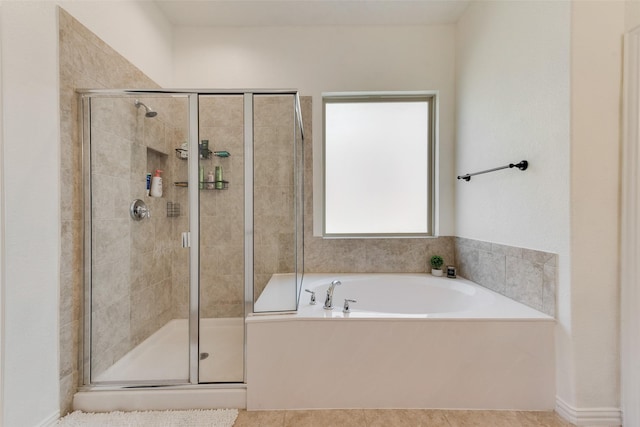bathroom featuring a stall shower, a garden tub, and tile patterned floors