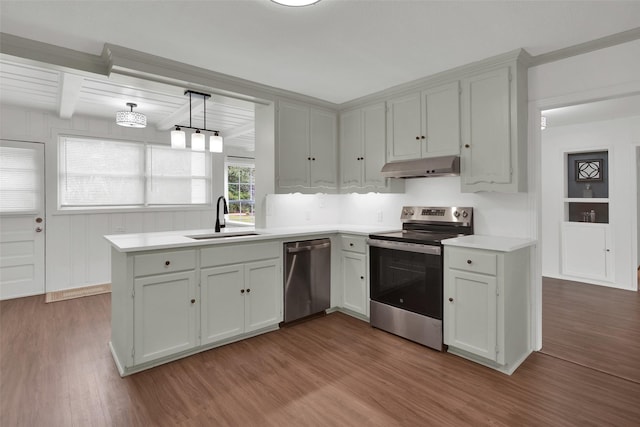 1501 W Day St, Denison, TX 75020 - kitchen with appliances with stainless steel finishes, a sink, under cabinet range hood, wood finished floors, and light countertops