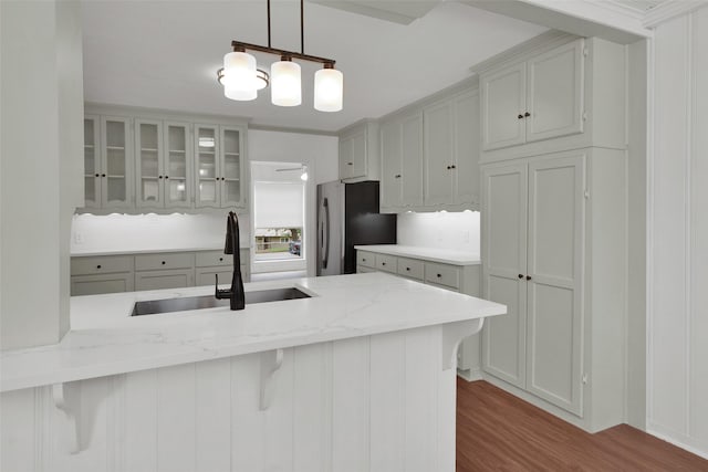 1501 W Day St, Denison, TX 75020 - kitchen featuring a sink, freestanding refrigerator, a breakfast bar area, dark wood finished floors, and glass insert cabinets