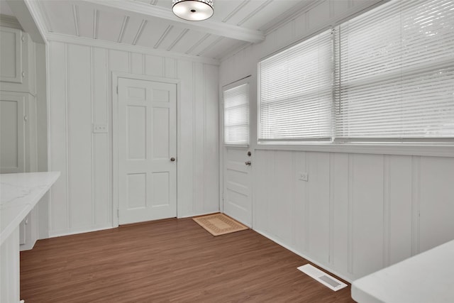 1501 W Day St, Denison, TX 75020 - unfurnished dining area with a decorative wall, wood finished floors, and beam ceiling
