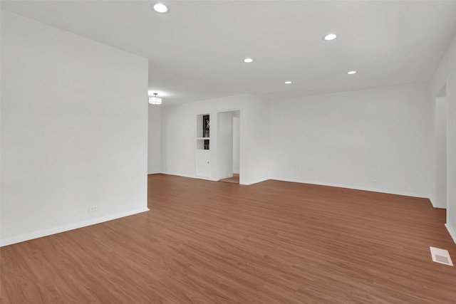 1501 W Day St, Denison, TX 75020 - spare room with wood finished floors, recessed lighting, and baseboards