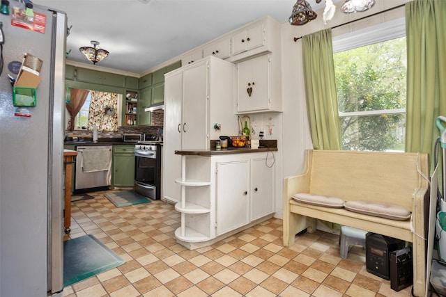 kitchen with open shelves, stainless steel appliances, green cabinetry, dark countertops, and white cabinets