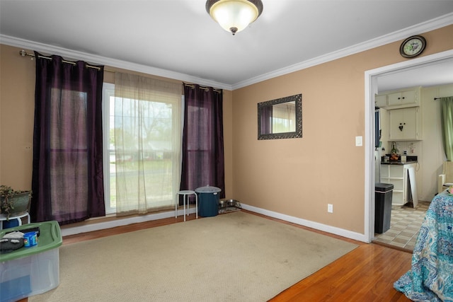 interior space with ornamental molding, light wood-style flooring, and baseboards