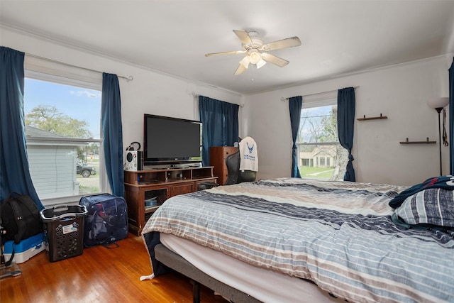 bedroom featuring wood finished floors, ornamental molding, and ceiling fan