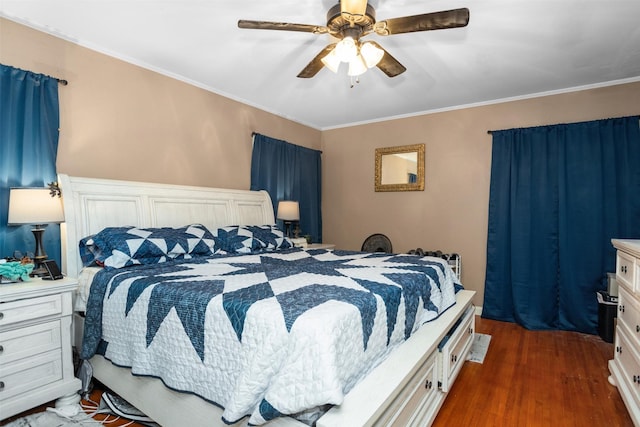 bedroom with dark wood-style flooring, ornamental molding, and ceiling fan