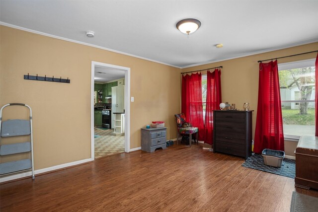 interior space featuring wood finished floors, ornamental molding, and baseboards