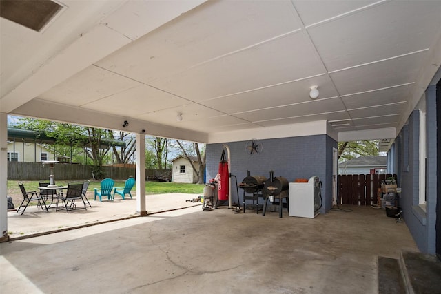 view of patio / terrace featuring a fenced backyard, a storage shed, washer / clothes dryer, and an outdoor structure
