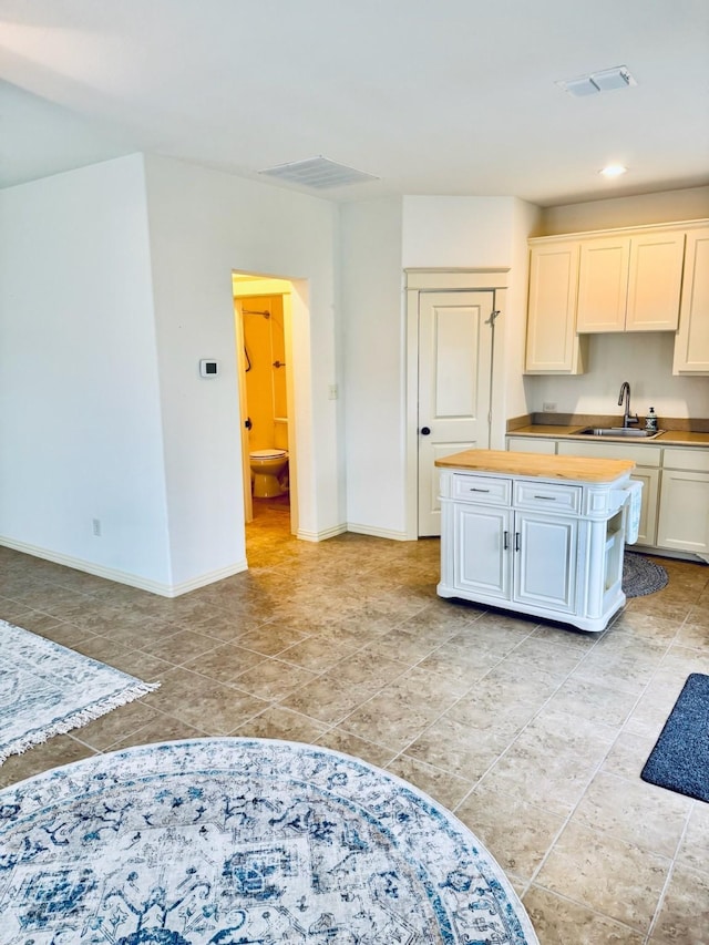7501 Darrow Dr, Mckinney, TX 75071 - kitchen with a sink, wooden counters, baseboards, a center island, and recessed lighting