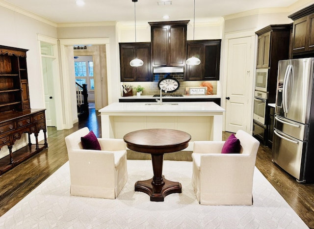 7501 Darrow Dr, Mckinney, TX 75071 - kitchen with appliances with stainless steel finishes, dark wood-style floors, light countertops, crown molding, and backsplash