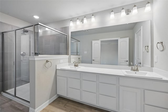 2832 Baneberry Ln, Mesquite, TX 75150 - bathroom featuring a stall shower, wood finished floors, double vanity, and baseboards