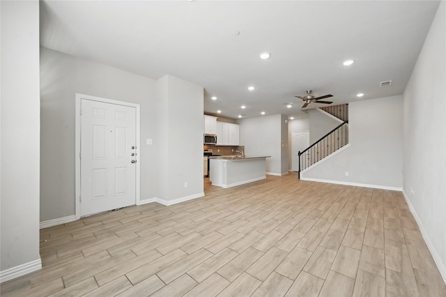 2832 Baneberry Ln, Mesquite, TX 75150 - unfurnished living room featuring light wood finished floors, stairway, baseboards, ceiling fan, and recessed lighting