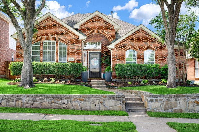9121 Rio Blanco Dr, Frisco, TX 75033 - view of front of house with brick siding, a shingled roof, and a front lawn