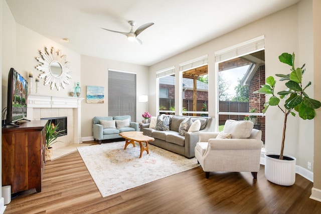 9121 Rio Blanco Dr, Frisco, TX 75033 - living room with a ceiling fan, wood finished floors, a tile fireplace, and baseboards