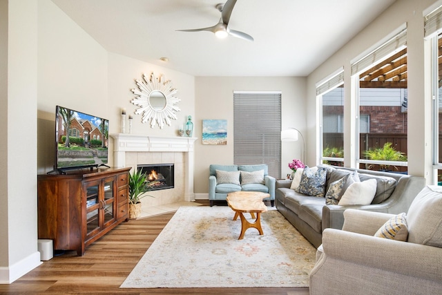 9121 Rio Blanco Dr, Frisco, TX 75033 - living area featuring wood finished floors, a tile fireplace, a ceiling fan, and baseboards