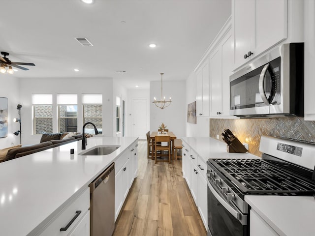 4508 English Maple Dr, Arlington, TX 76005 - kitchen with appliances with stainless steel finishes, a sink, open floor plan, light countertops, and light wood finished floors
