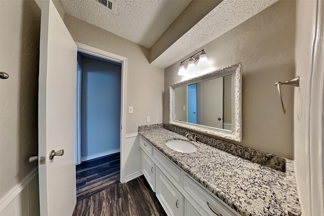 2800 Glen Forest Ln, Plano, TX 75023 - bathroom featuring a textured ceiling, wood finished floors, and vanity