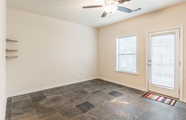 13900 Noel Rd Unit 2, Dallas, TX 75240 - spare room featuring a ceiling fan, baseboards, and dark stone finish flooring