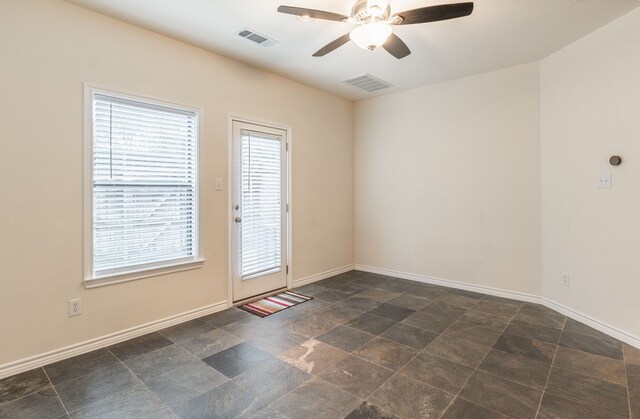 13900 Noel Rd Unit 2, Dallas, TX 75240 - empty room featuring ceiling fan, baseboards, and dark stone finish floors