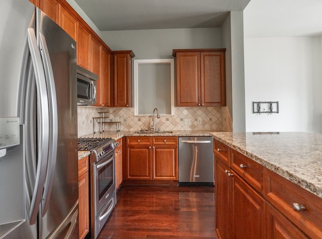 13900 Noel Rd Unit 2, Dallas, TX 75240 - kitchen with stainless steel appliances, a sink, dark wood-style floors, and brown cabinetry