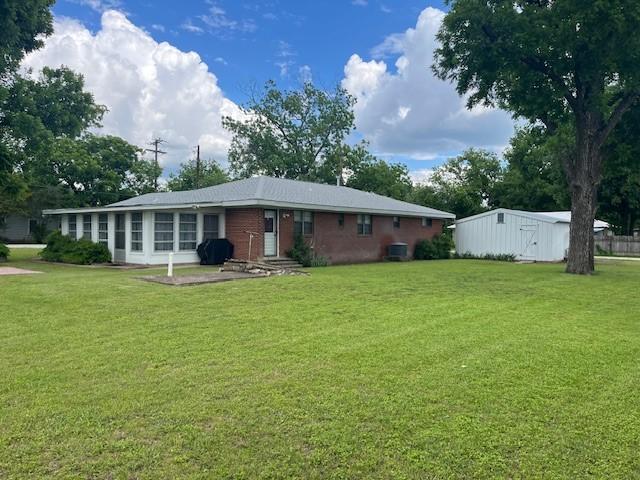 back of property with a lawn and an outbuilding