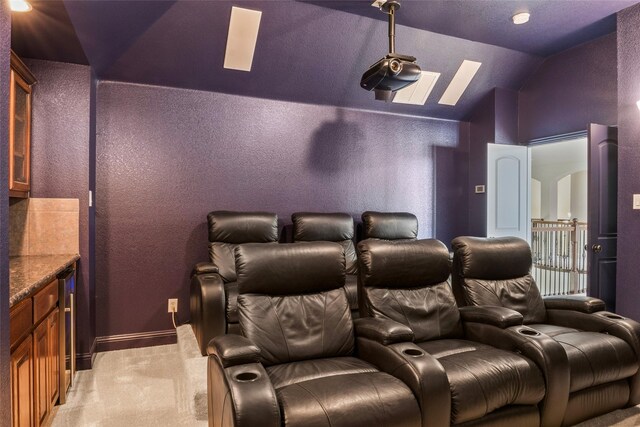2512 Mona Vale Rd, Trophy Club, TX 76262 - cinema room with light colored carpet, lofted ceiling, a skylight, baseboards, and a textured wall