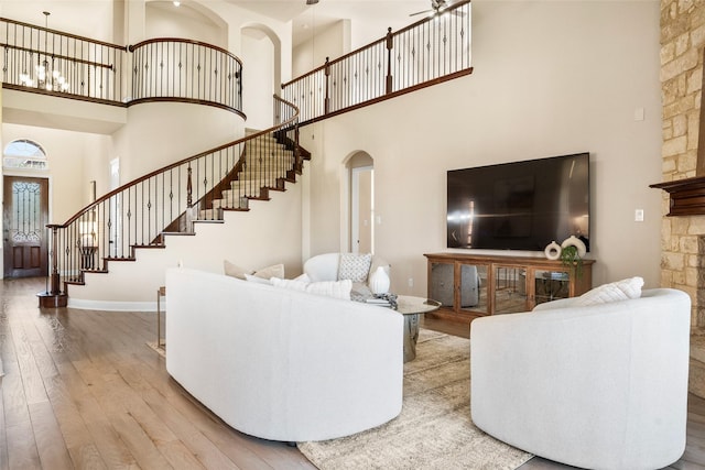 2512 Mona Vale Rd, Trophy Club, TX 76262 - living room featuring a towering ceiling, wood-type flooring, stairway, arched walkways, and baseboards
