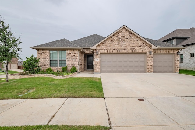 14601 Donner Trl, Fort Worth, TX 76262 - view of front of home featuring a garage, brick siding, driveway, a front yard, and a shingled roof