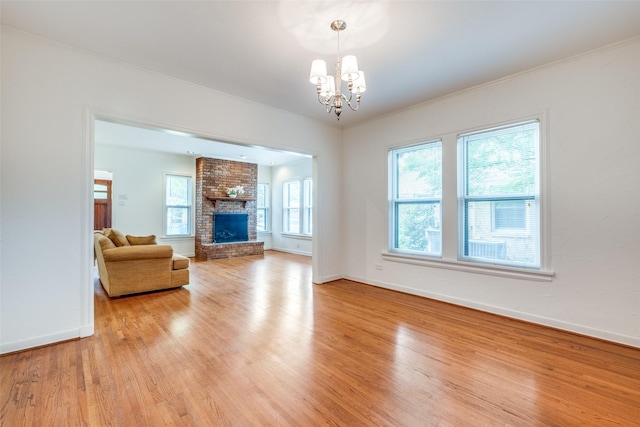 5322 Stoneleigh Ave, Dallas, TX 75235 - living room with light wood-type flooring, a chandelier, baseboards, a brick fireplace, and crown molding