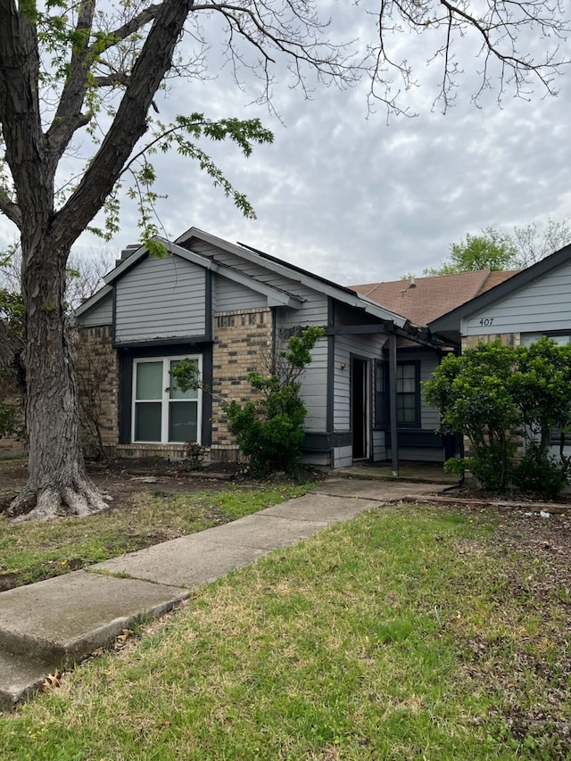 405 Liberty Pl, Grand Prairie, TX 75052 - view of front facade with a front yard and brick siding