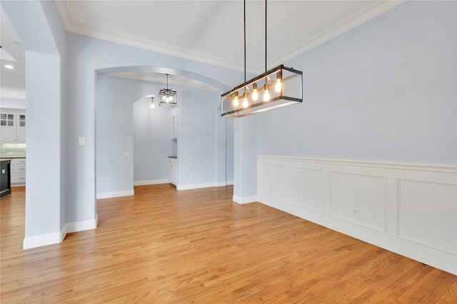 3706 Plum Vista Pl, Arlington, TX 76005 - unfurnished dining area featuring ornamental molding, arched walkways, light wood-style flooring, and baseboards