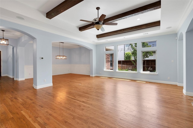 3706 Plum Vista Pl, Arlington, TX 76005 - unfurnished living room featuring light wood finished floors, a ceiling fan, beam ceiling, a wainscoted wall, and arched walkways