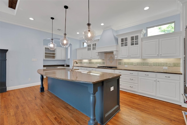 3706 Plum Vista Pl, Arlington, TX 76005 - kitchen featuring premium range hood, gas stovetop, a breakfast bar area, crown molding, and tasteful backsplash