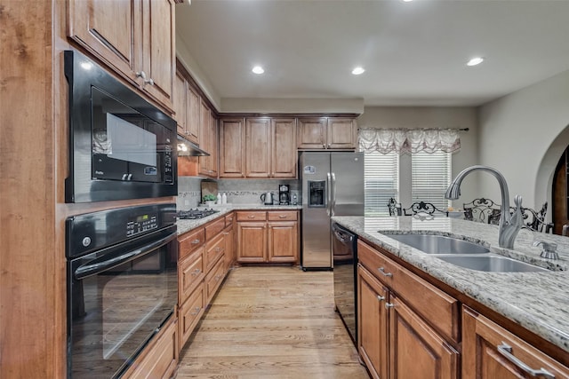 7817 Harvest Hill Ln, Mckinney, TX 75071 - kitchen with black appliances, a sink, light wood finished floors, light stone countertops, and recessed lighting