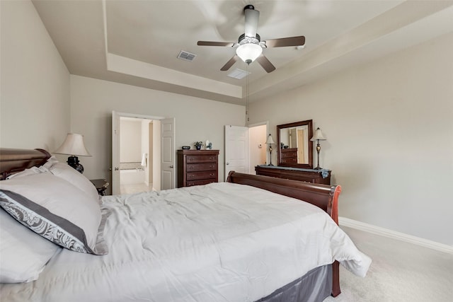 7817 Harvest Hill Ln, Mckinney, TX 75071 - carpeted bedroom with a tray ceiling, baseboards, ceiling fan, and ensuite bathroom