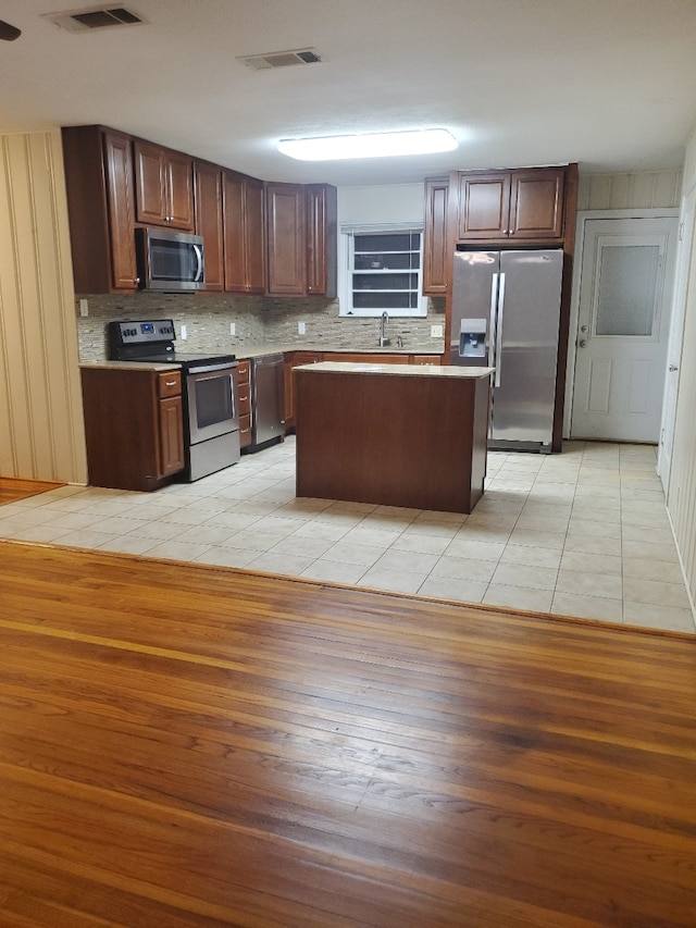 1600 N Frances St, Terrell, TX 75160 - kitchen featuring appliances with stainless steel finishes, a center island, backsplash, and a sink