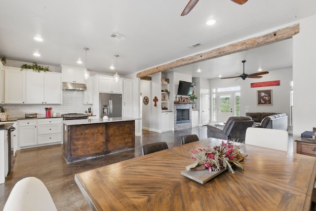 dining space with a ceiling fan, recessed lighting, a fireplace, and beam ceiling