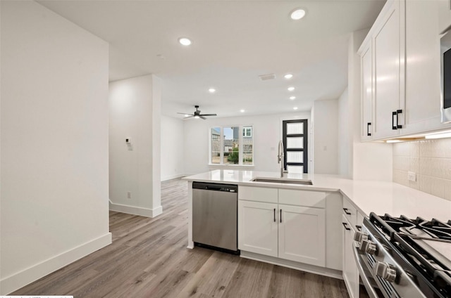 4702 Smokey Quartz Ln, Arlington, TX 76005 - kitchen with appliances with stainless steel finishes, a sink, a peninsula, white cabinetry, and recessed lighting