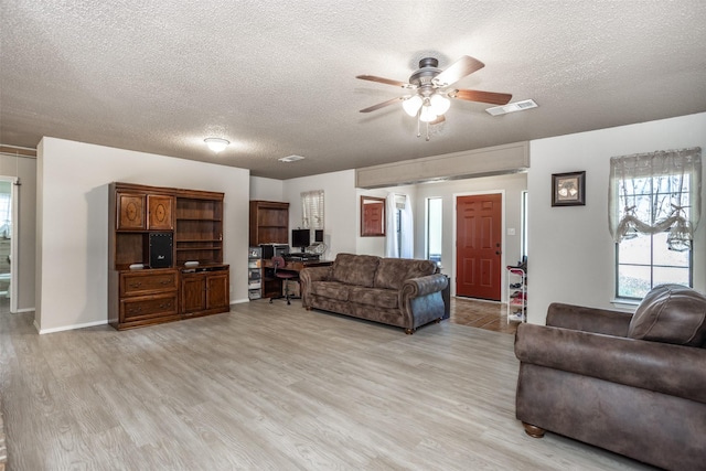 1916 N Lake Trl, Denton, TX 76201 - living room featuring ceiling fan, light wood-style flooring, a textured ceiling, and baseboards