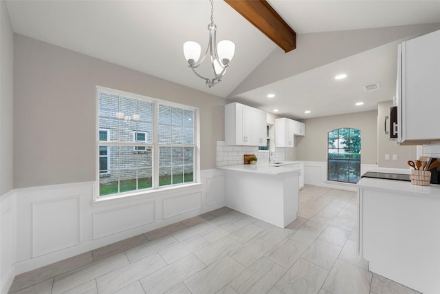 2100 Valley Forge Dr, Plano, TX 75075 - kitchen with a peninsula, a chandelier, a sink, wainscoting, and a decorative wall