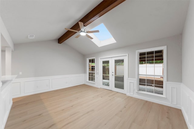 2100 Valley Forge Dr, Plano, TX 75075 - empty room featuring a skylight, light wood-style floors, ceiling fan, wainscoting, and a decorative wall