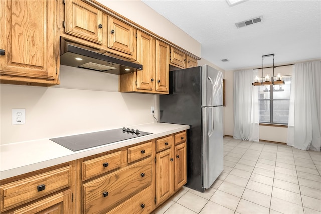 kitchen featuring freestanding refrigerator, under cabinet range hood, black electric stovetop, light countertops, and light tile patterned floors