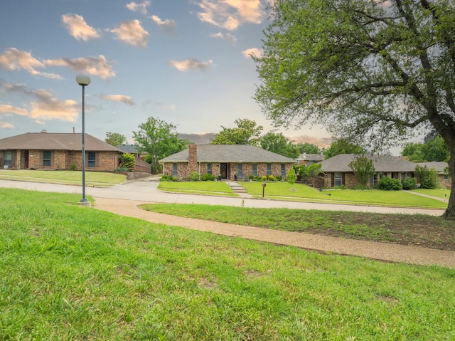 view of front of home featuring a front lawn and brick siding