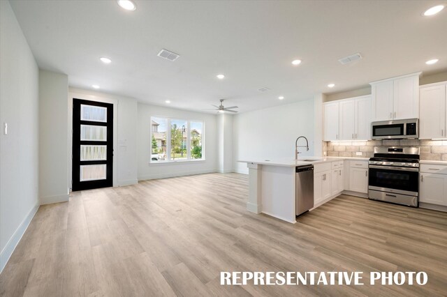 4716 Smokey Quartz Ln, Arlington, TX 76005 - kitchen with appliances with stainless steel finishes, open floor plan, a peninsula, backsplash, and a ceiling fan
