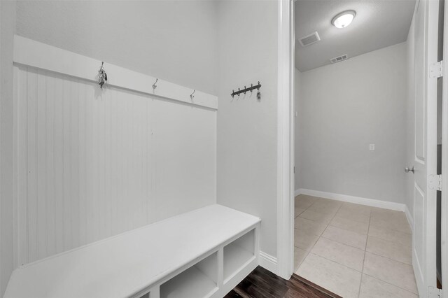 mudroom with baseboards and tile patterned floors