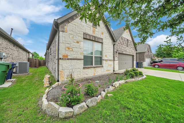 view of side of property with stone siding, cooling unit, driveway, and a garage