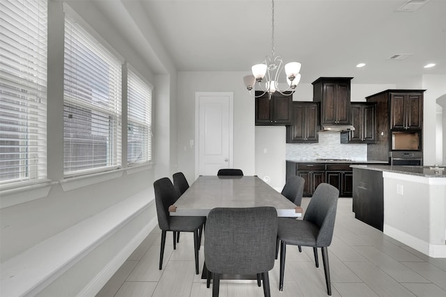 dining space with a chandelier, baseboards, and recessed lighting